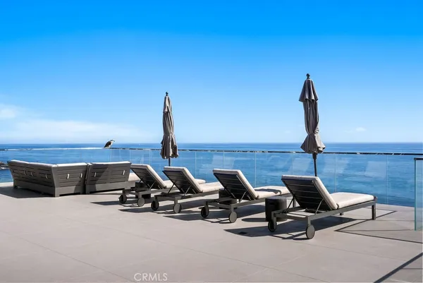 a view of a terrace with lawn chairs