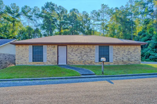 a brick house with a yard in front of it