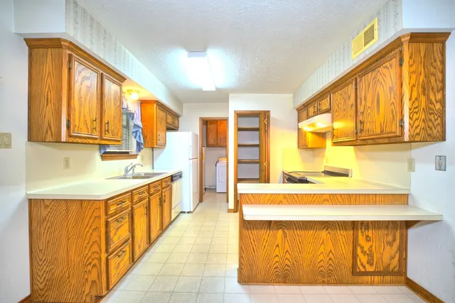 a large white kitchen with a large window