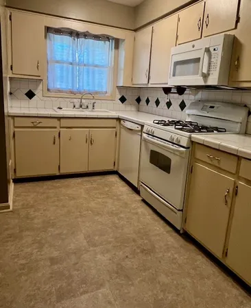 a kitchen with stainless steel appliances a stove a sink and a refrigerator