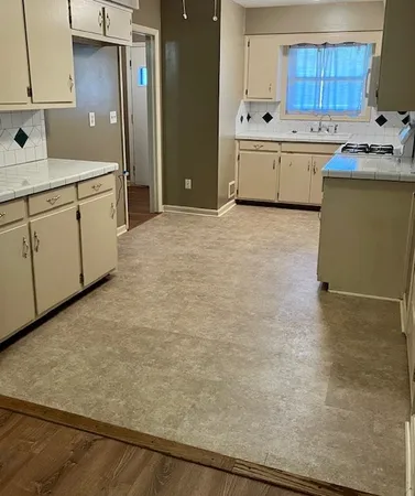 a kitchen with a sink a stove and cabinets