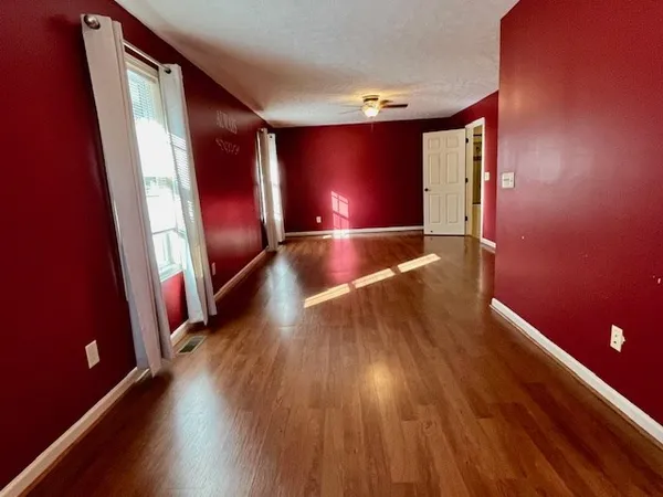 a view of an empty room with wooden floor