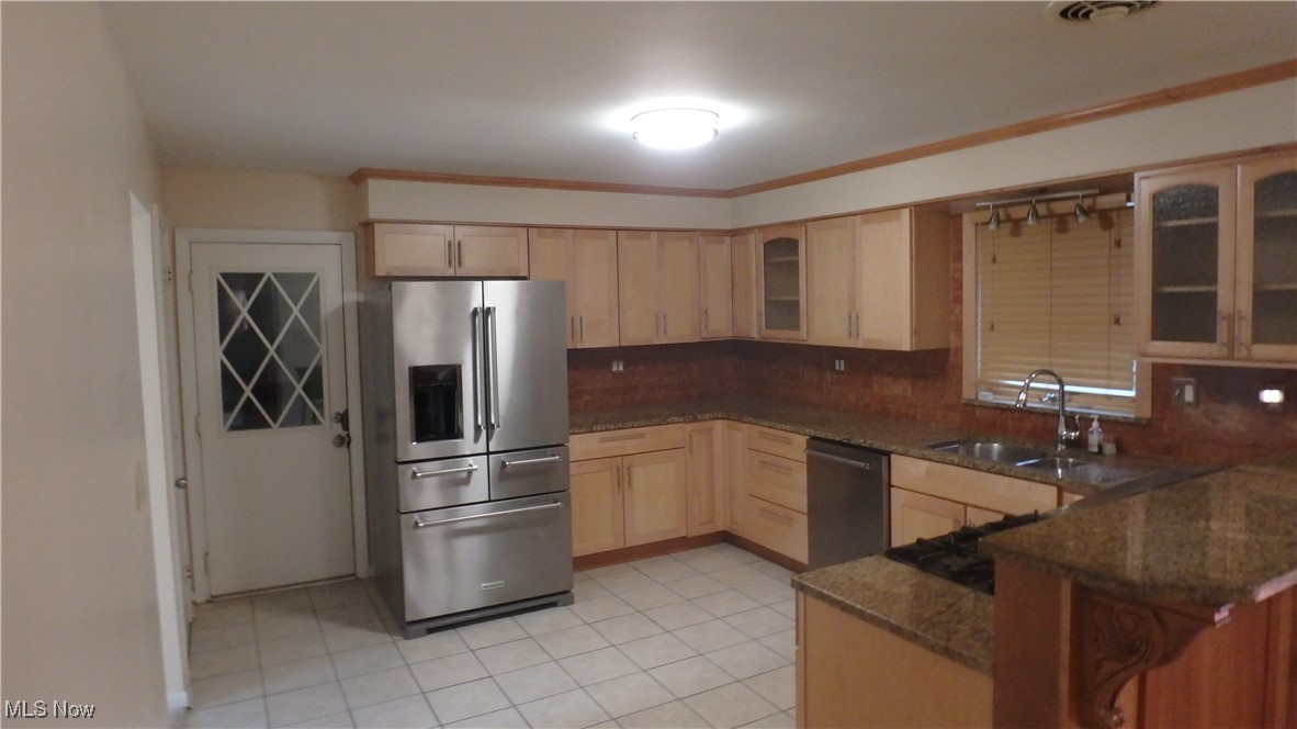 2901 Dentzler Road Parma, OH 44134 - Photo 9 of 25 Kitchen with stainless steel appliances, light brown cabinets, backsplash, and a peninsula