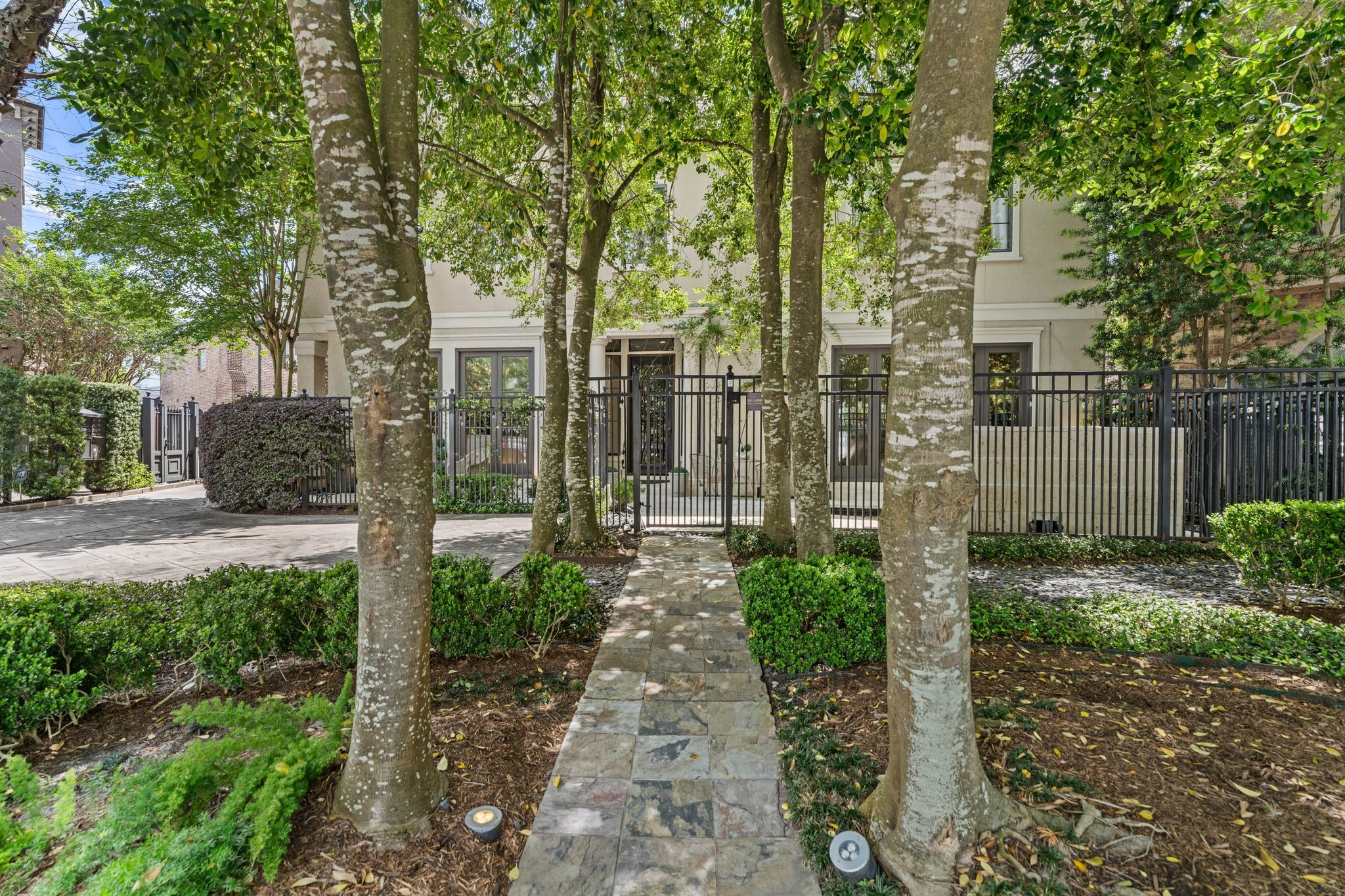 30 Hackberry Lane, Unit A Houston, TX 77027 - Photo 3 of 42 The slate walkway travels through the tree canopy leads to the ornate, wrought-iron pedestrian gate.