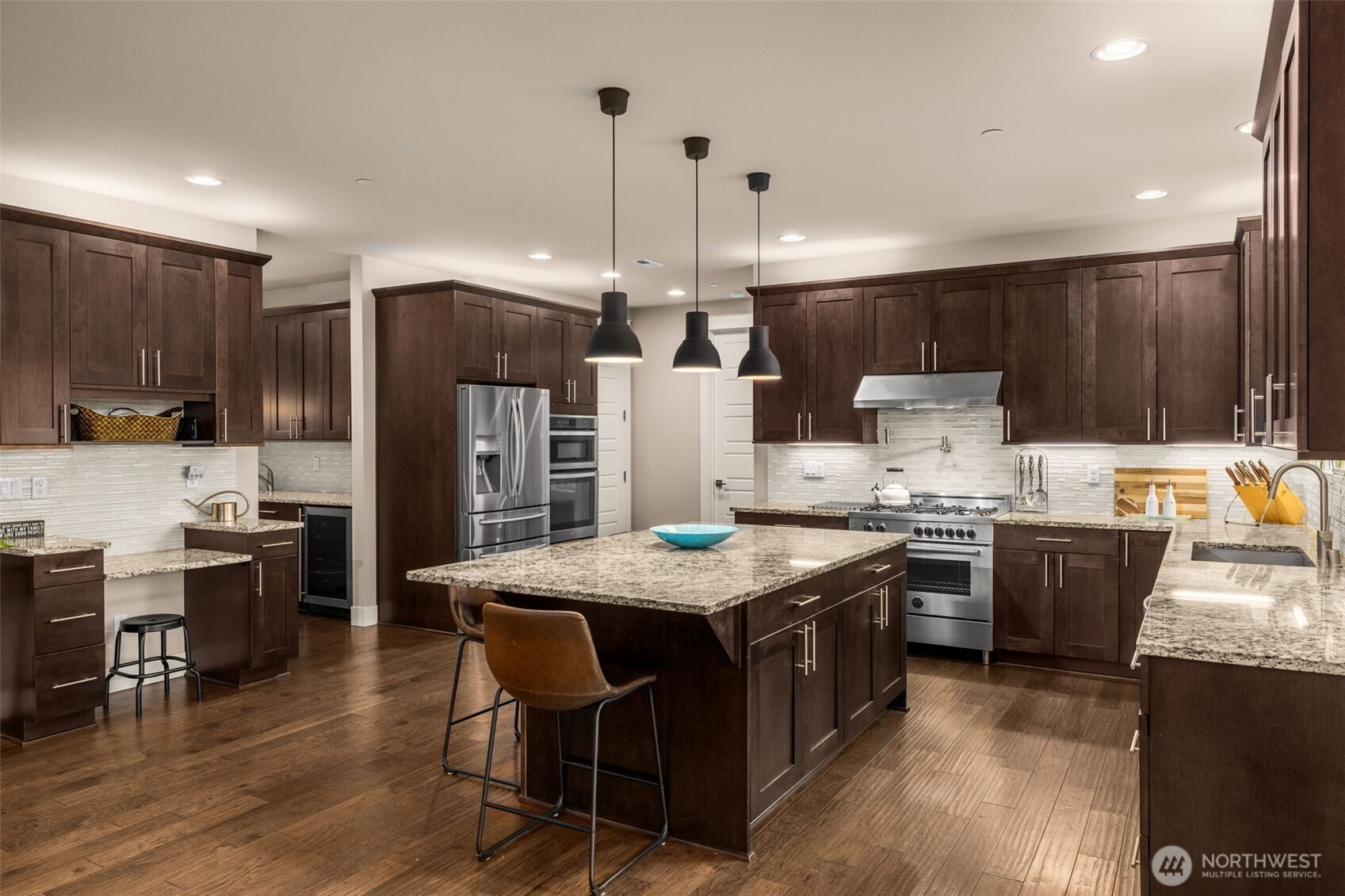 10219 Kelly Road Northeast Carnation, WA 98014 - Photo 11 of 38 a kitchen with stainless steel appliances kitchen island granite countertop a stove refrigerator a sink a dining table and chairs