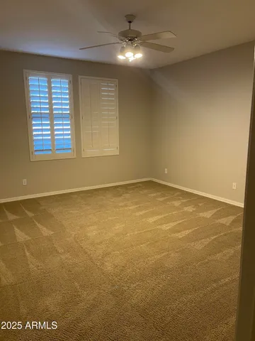 an empty room with a fan and a window