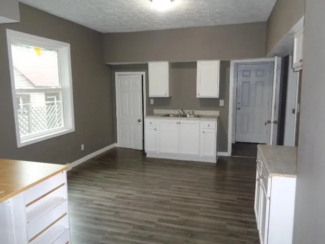 a kitchen with granite countertop a stove a sink and a refrigerator