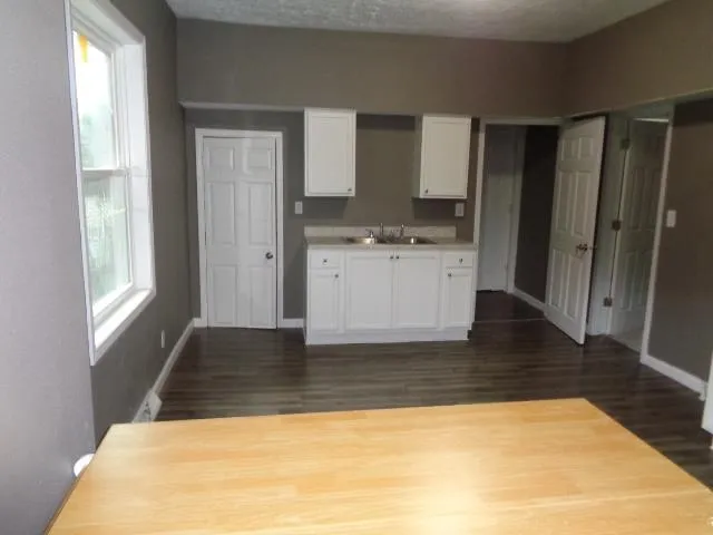a view of a kitchen with wooden floor and a window