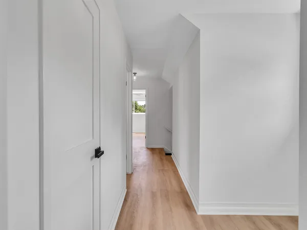 a view of a hallway with wooden floor