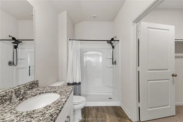 a bathroom with a granite countertop sink toilet and shower