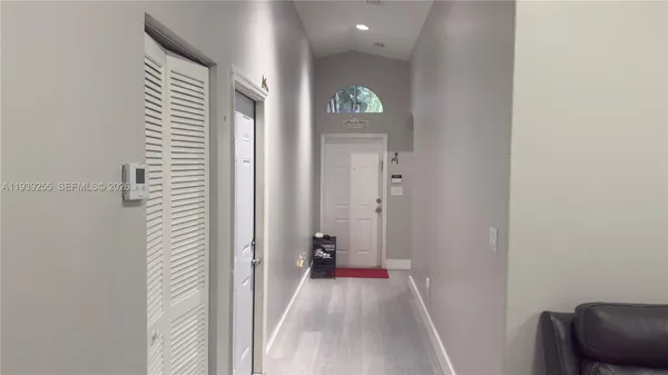 a view of a hallway with wooden floor and a bathroom