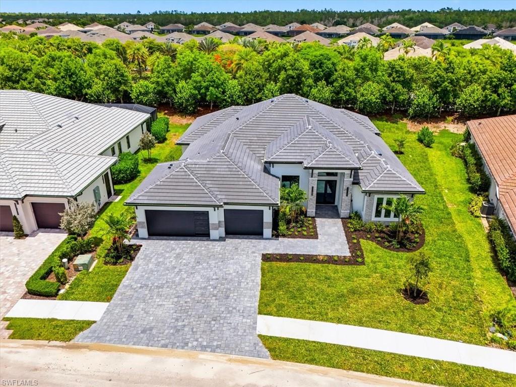 14318 Charthouse Circle Naples, FL 34114 - Photo 25 of 36 a front view of a house with garden