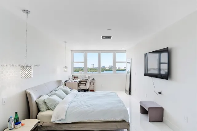 a bedroom with a bed and large window