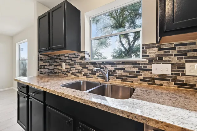 a large kitchen with stainless steel appliances kitchen island granite countertop a stove sink and cabinets