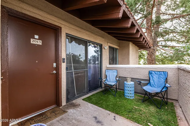 a view of a chair and table in backyard of the house