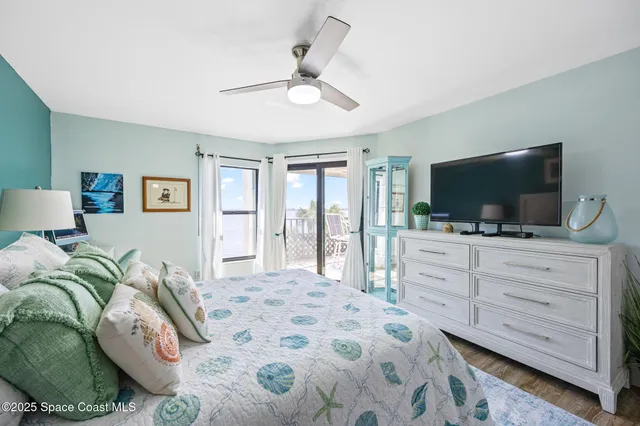 a bedroom with a bed television and a large window