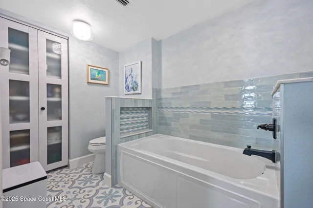 a bath room with a toilet and a bath tub