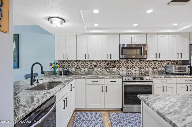 a kitchen with stainless steel appliances granite countertop a sink stove oven and refrigerator