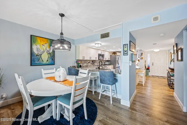 a dining room with furniture a chandelier and wooden floor