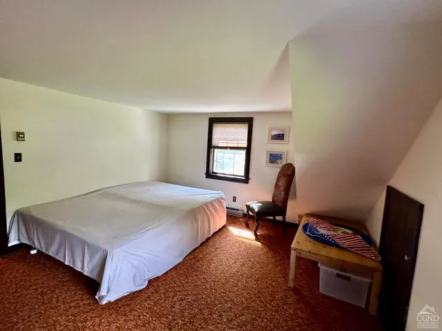 a bed sitting in a bedroom next to a window