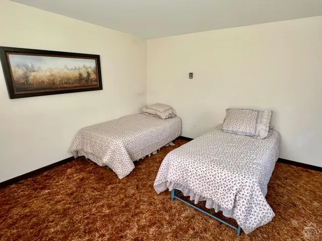 a bedroom with two beds and painting on the wall