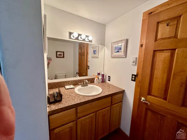 a bathroom with a sink vanity granite tub and a mirror