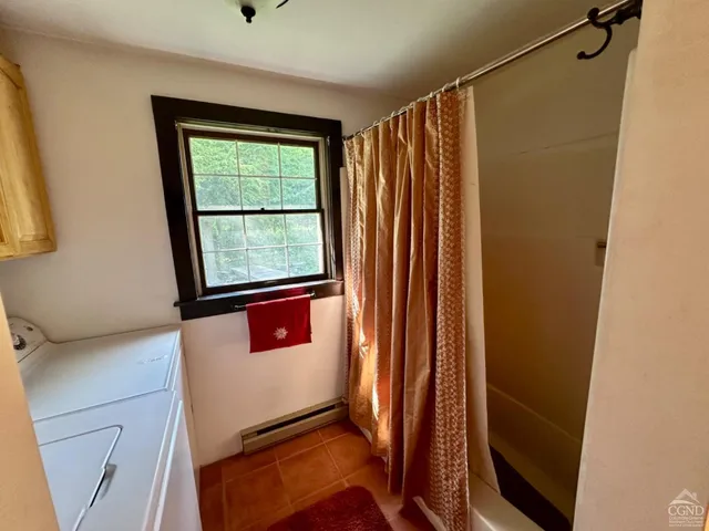 a bathroom with a window and a shower