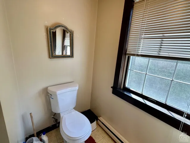 a bathroom with a toilet a sink and mirror