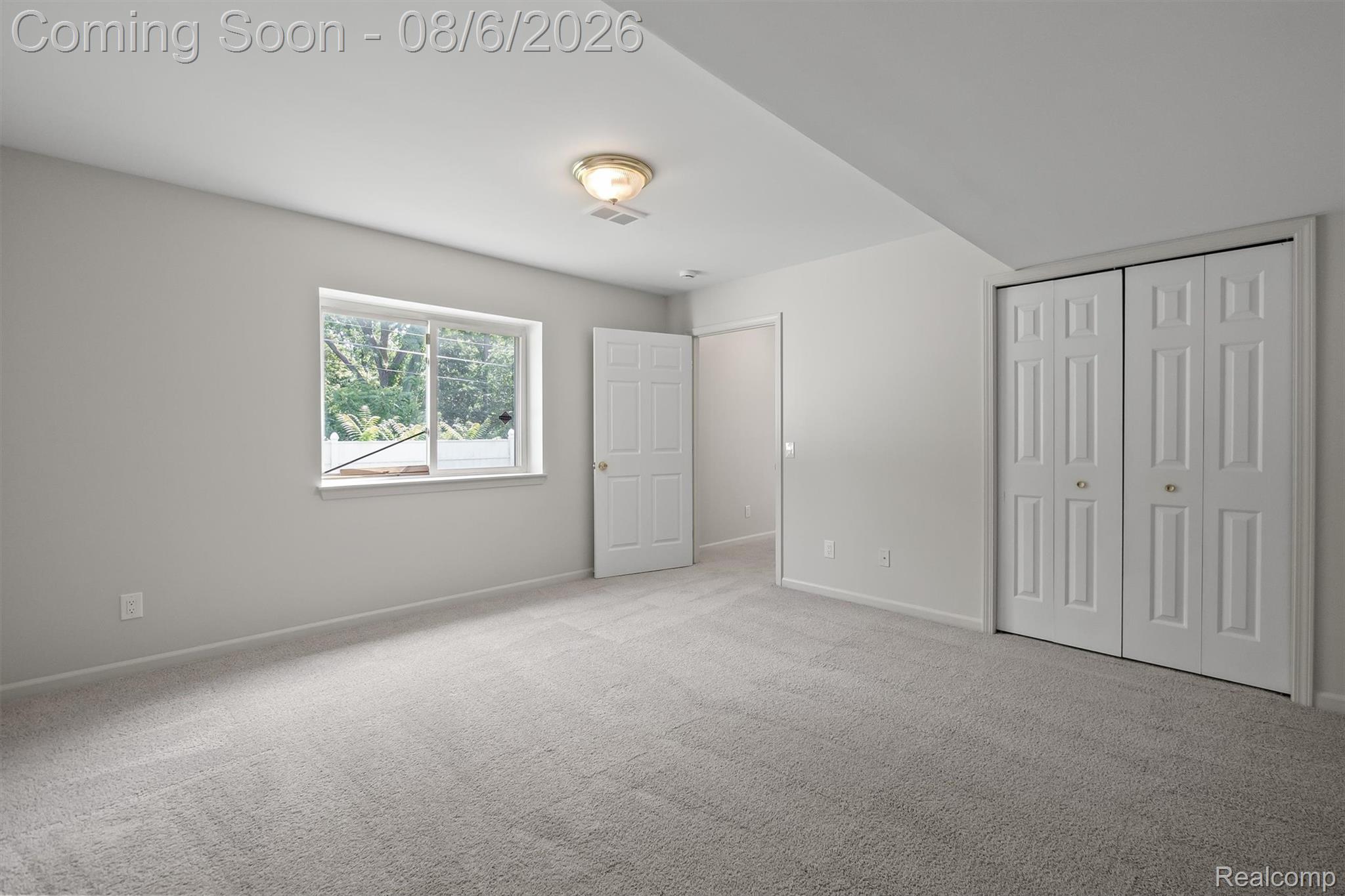 4427 Hannan Road Wayne, MI 48184 - Photo 24 of 33 Spacious bedroom featuring neutral carpet flooring, dual closets with six-panel doors, a large window with natural light, and a ceiling-mounted light fixture