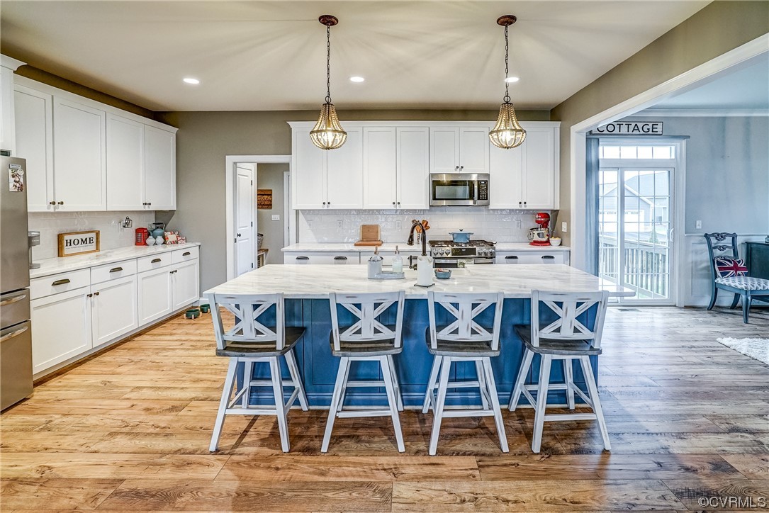 709 West Vaughan Road Ashland, VA 23005 - Photo 15 of 50 a kitchen with stainless steel appliances kitchen island granite countertop a wooden table chairs sink and cabinets
