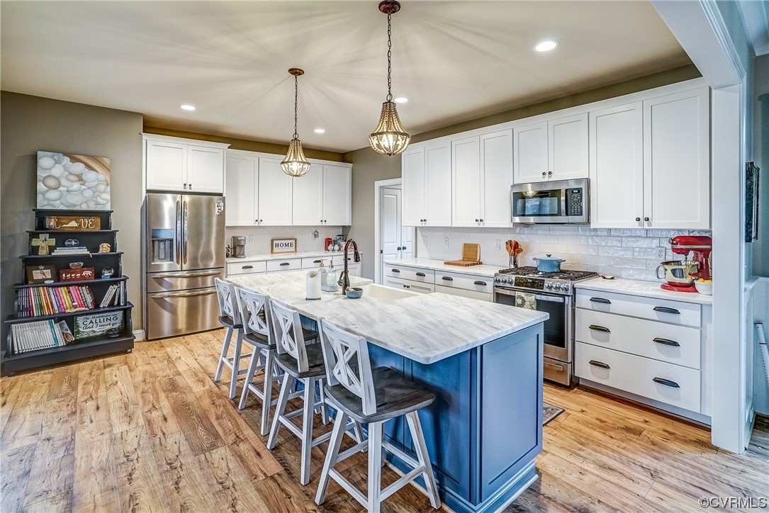 709 West Vaughan Road Ashland, VA 23005 - Photo 16 of 50 a kitchen with stainless steel appliances kitchen island granite countertop a table chairs refrigerator and a sink