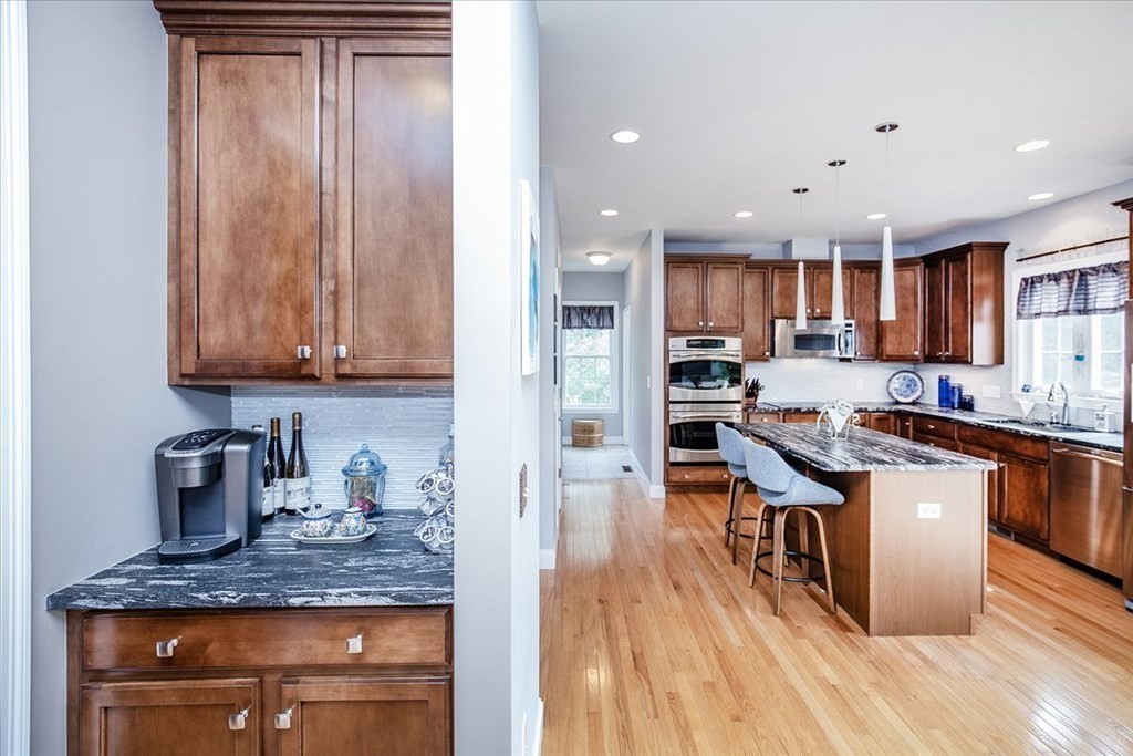11 Sparrow Lane Danvers, MA 01923 - Photo 17 of 41 a kitchen with stainless steel appliances granite countertop wooden cabinets a refrigerator a sink a stove and a wooden floors