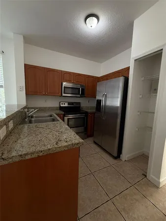 a kitchen with a refrigerator sink and stove