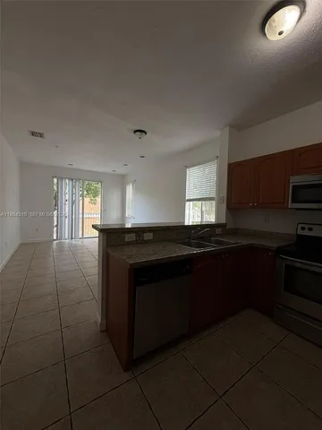 a kitchen with granite countertop a stove a sink and a microwave