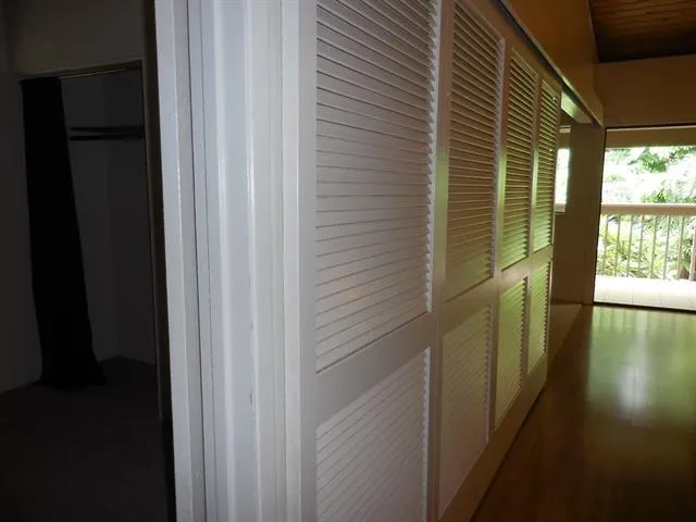 a view of empty room with wooden floor and a window