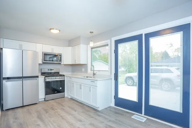 a kitchen with white cabinets and appliances