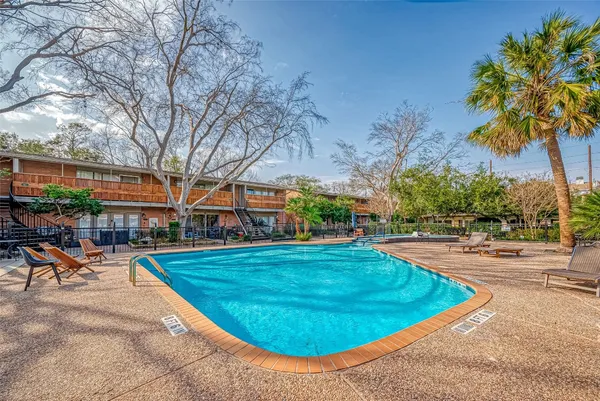 a view of a swimming pool and lounge chairs