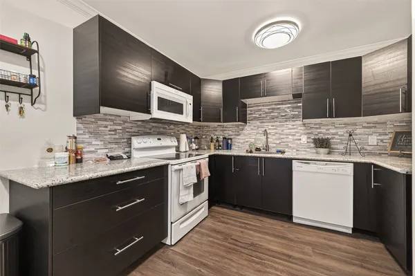 a kitchen with stainless steel appliances granite countertop a sink stove cabinets and wooden floor