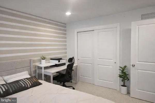 a bedroom with a bed and a potted plant