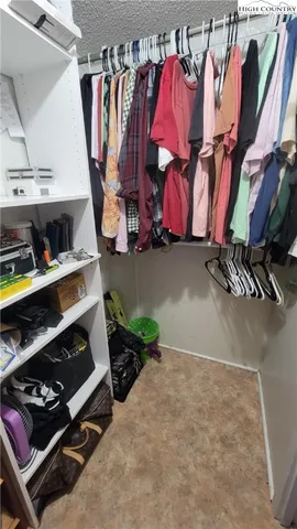 a view of walk in closet with clothes and shoes