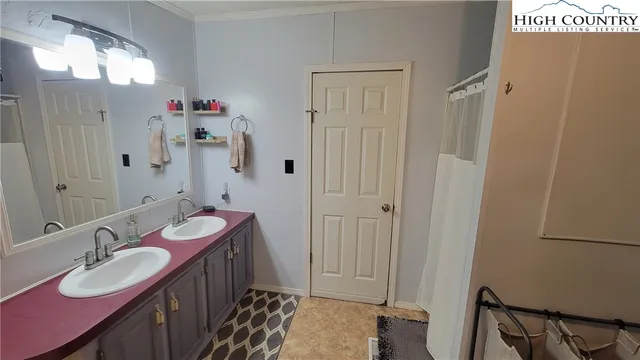 a bathroom with a double vanity sink mirror and shower
