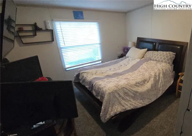 a bed sitting in a bedroom next to a window