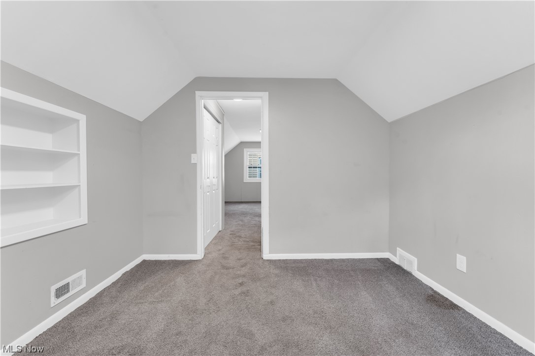 18805 Homeway Road Cleveland, OH 44135 - Photo 19 of 23 Additional living space with built in features, vaulted ceiling, and dark colored carpet