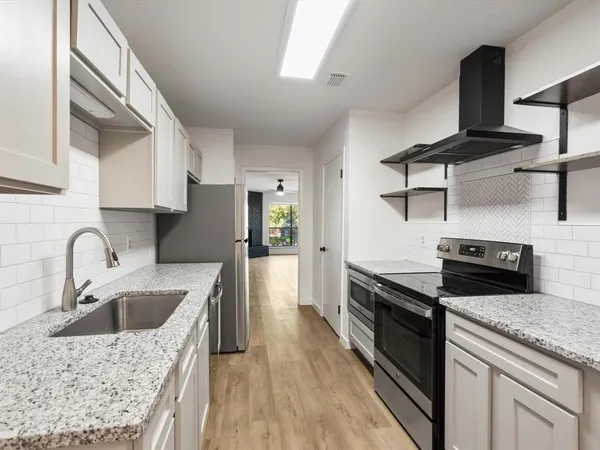 a kitchen with a stove a sink and a refrigerator