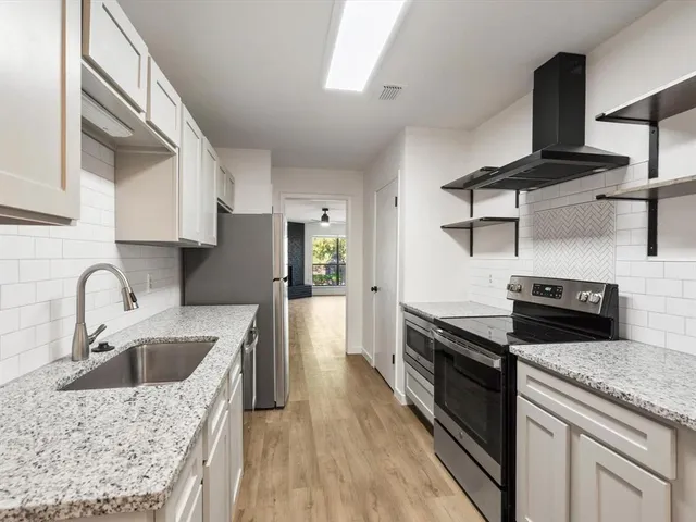 a kitchen with a stove a sink and a refrigerator