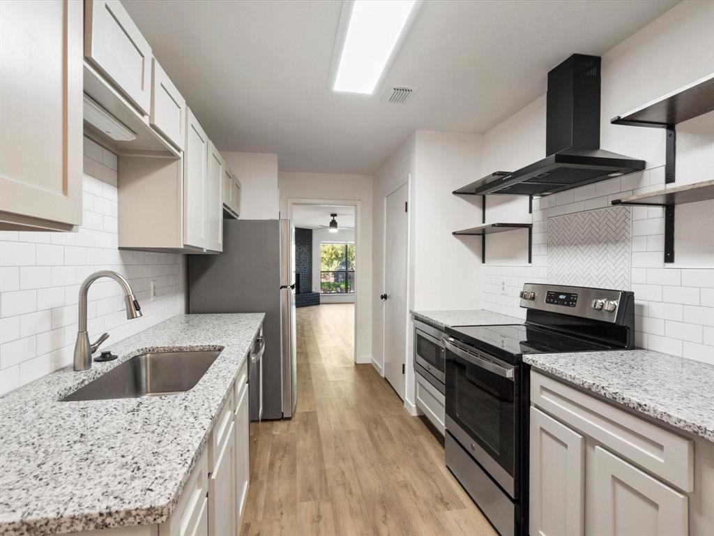 1117 South Rusk Street, Unit 1117 Weatherford, TX 76086 - Photo 13 of 16 a kitchen with a stove a sink and a refrigerator