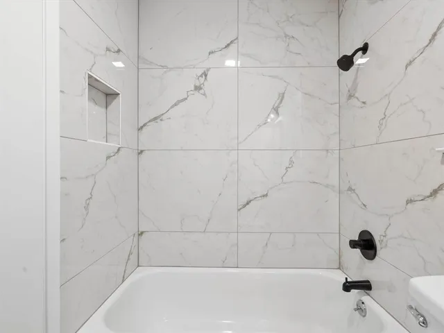 a bathroom with a bathtub and shower