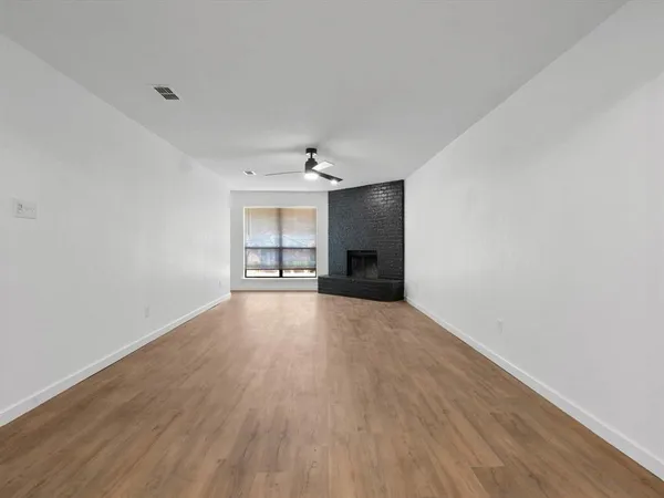 a view of a livingroom with wooden floor and a ceiling fan