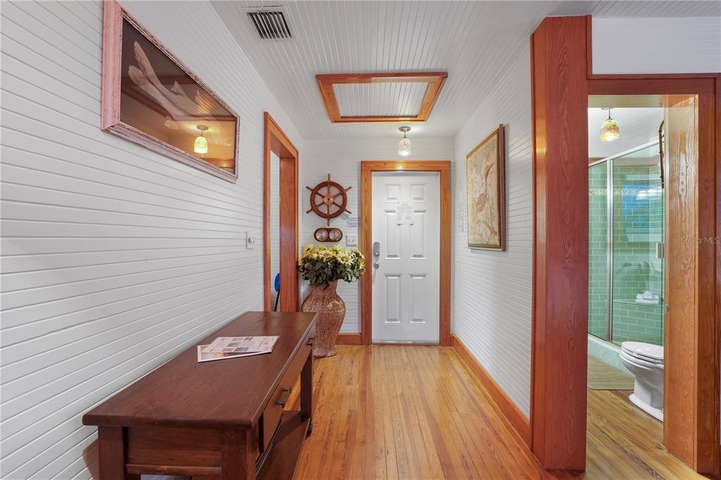 702 Pass A Grille Way St. Pete Beach, FL 33706 - Photo 23 of 41 a view of a hallway with furniture and wooden floor