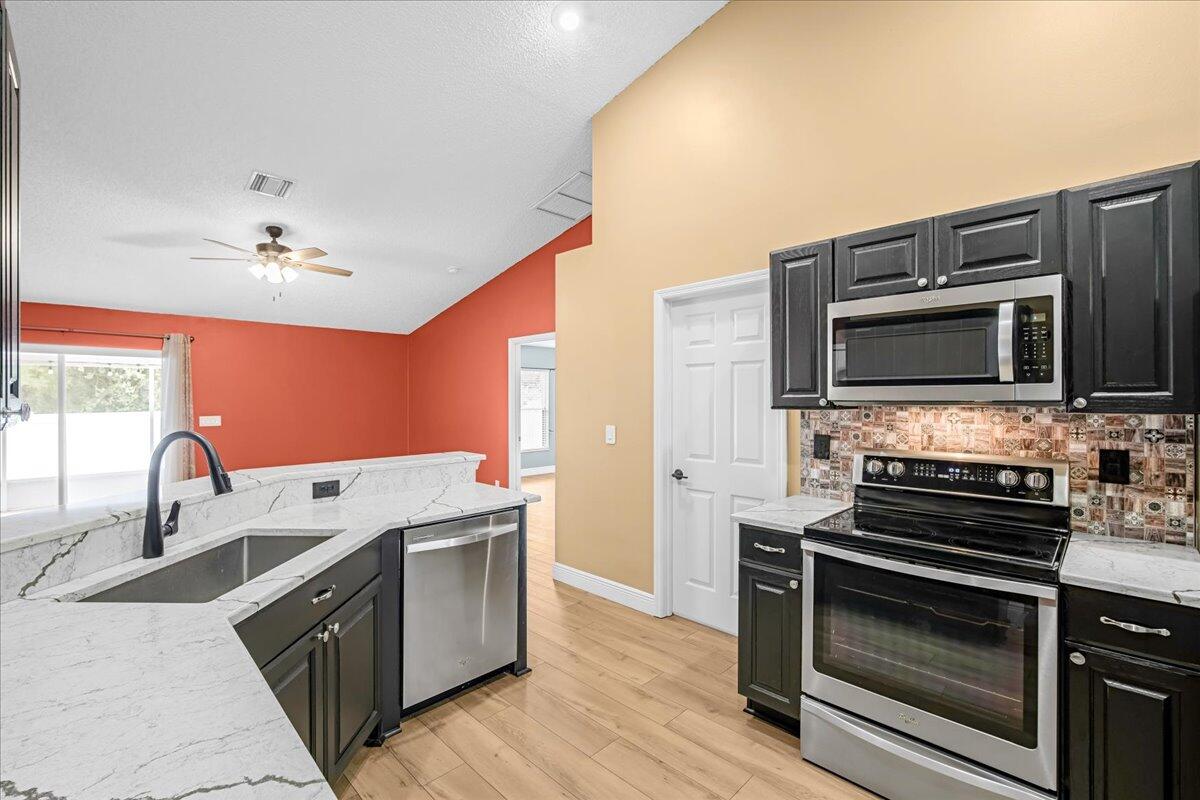 6445 Ainsworth Road Cocoa, FL 32927 - Photo 13 of 31 a kitchen with a stove and a microwave